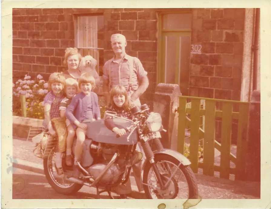 Family motorbike photograph before restoration, showing heavy colour fading